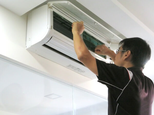 Aircon technician removing aircon filters for cleaning