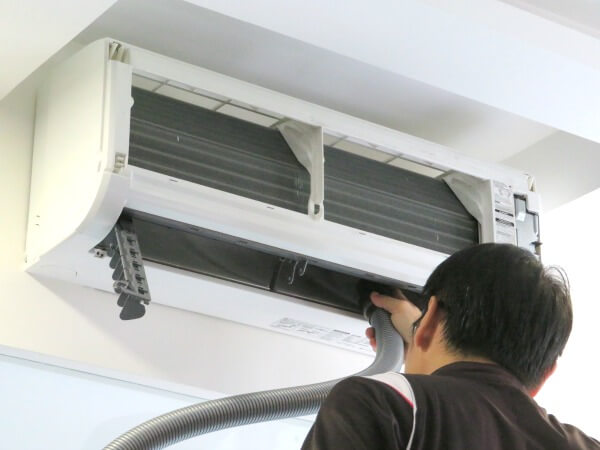 Aircon technician vacuum clean the right side of the aircon squirrrel cage fan